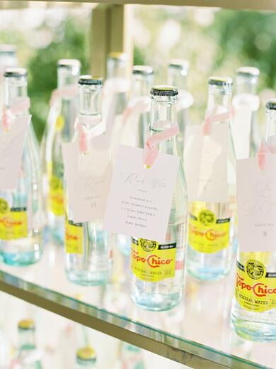 Favor Topo Chico Escort Cards Tied with Blush Ribbon on Gold Shelf