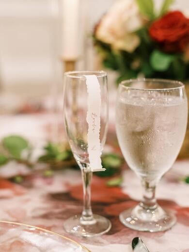 Delicate Scroll Wedding Place Card with Deckled Edges on Champagne Glass